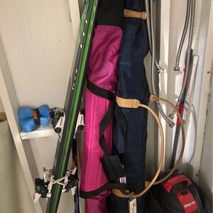3 sets of skis with bags and poles